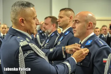 Funkcjonariusze lubuskiej policji w mundurach galowych podczas uroczystej ceremonii wręczania odznaczeń.